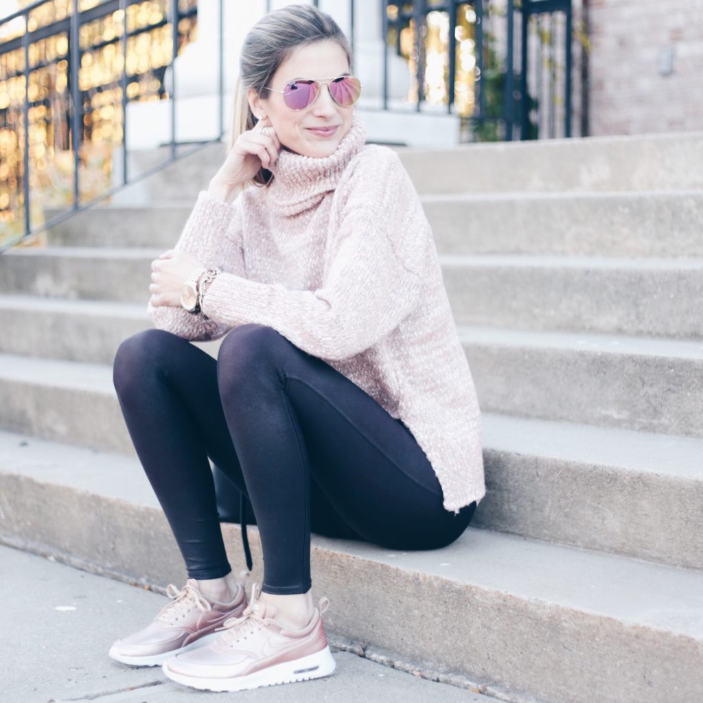 athleisure outfit: pink turtleneck sweater over wine colored spanx leggings and rose gold nike sneakers
