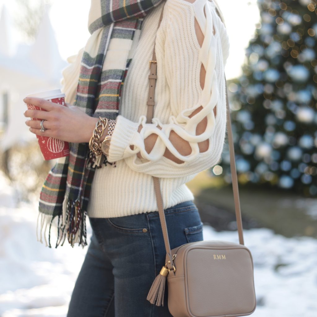 Crisscross sleeve white sweater with monogrammed taupe crossbody bag