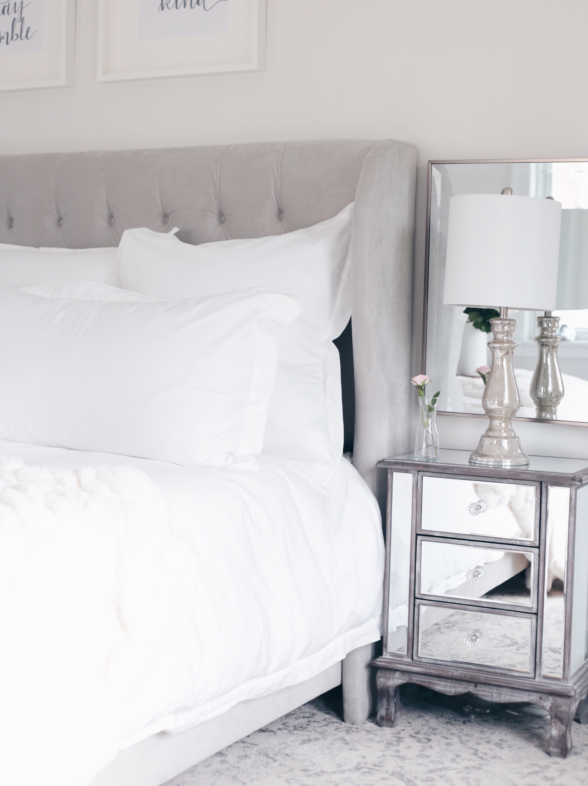 organic white bedding and mirrored night tables in master bedroom
