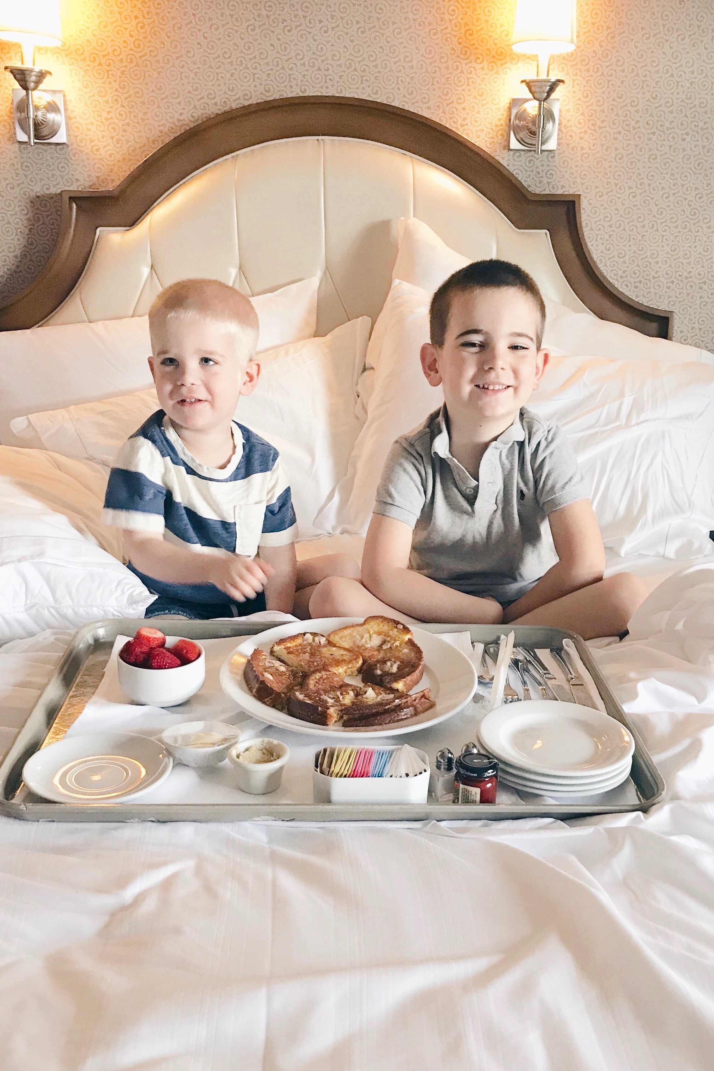 meal plans to save money on a Disney vacation - 2 little boys eating breakfast in bed