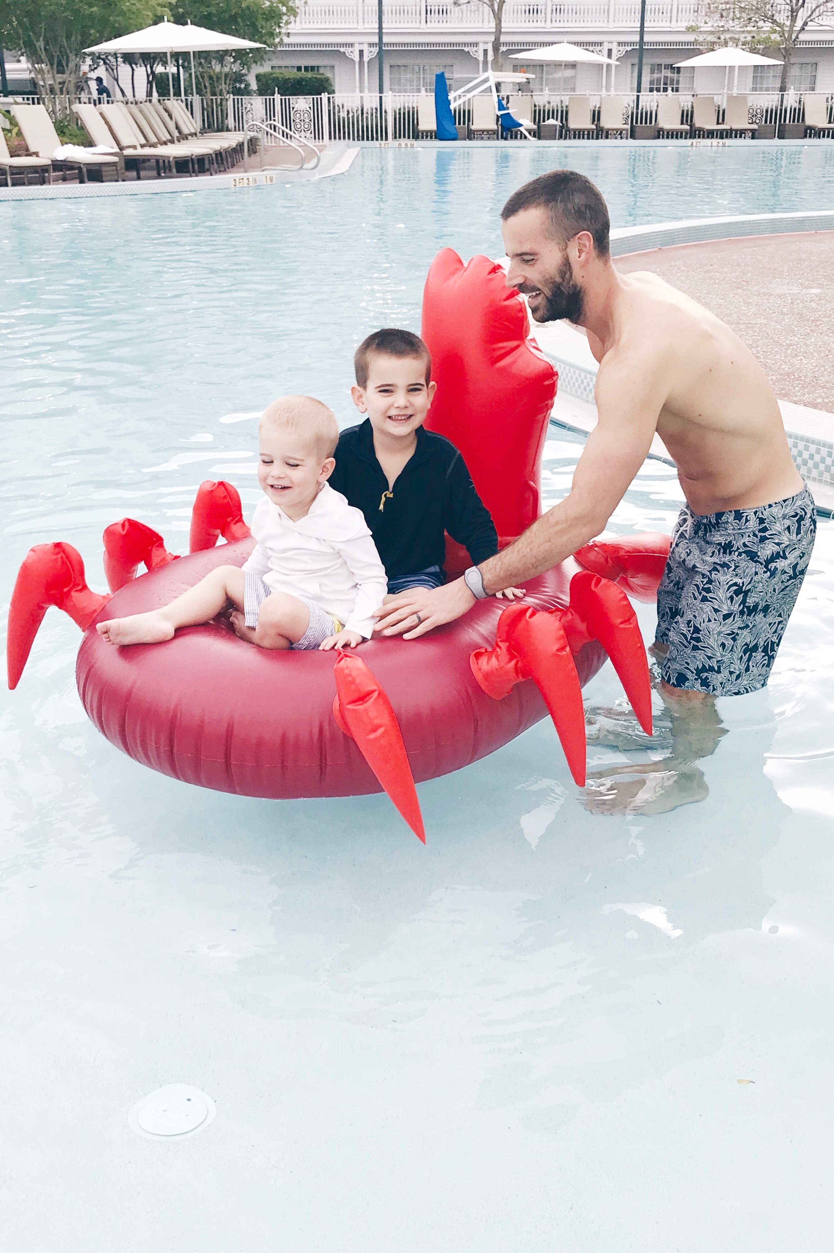little mermaid pool party - two young boys with Dad on sebastian pool float