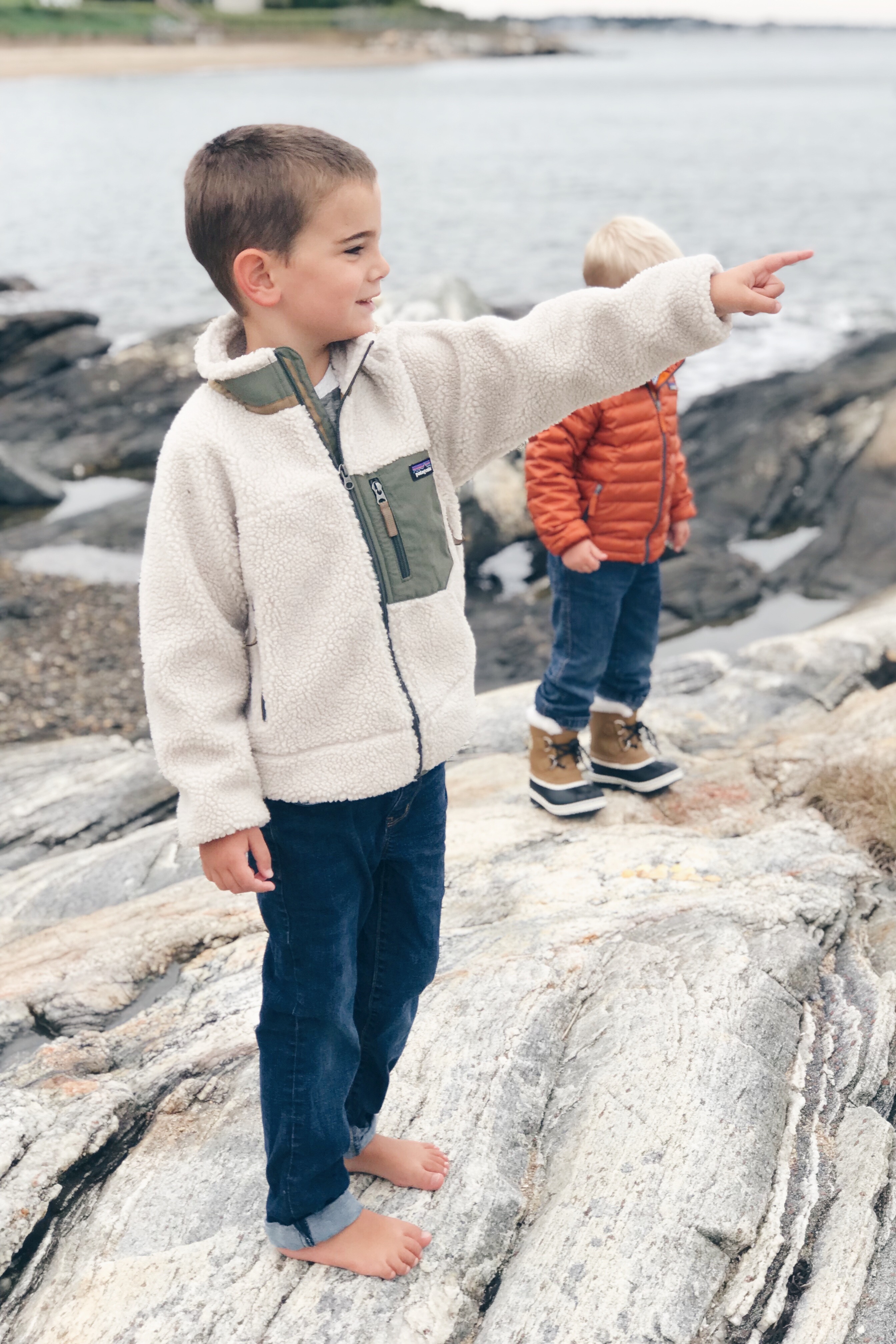 Fall Bucket list for families - young boy at beach in Patagonia jacket