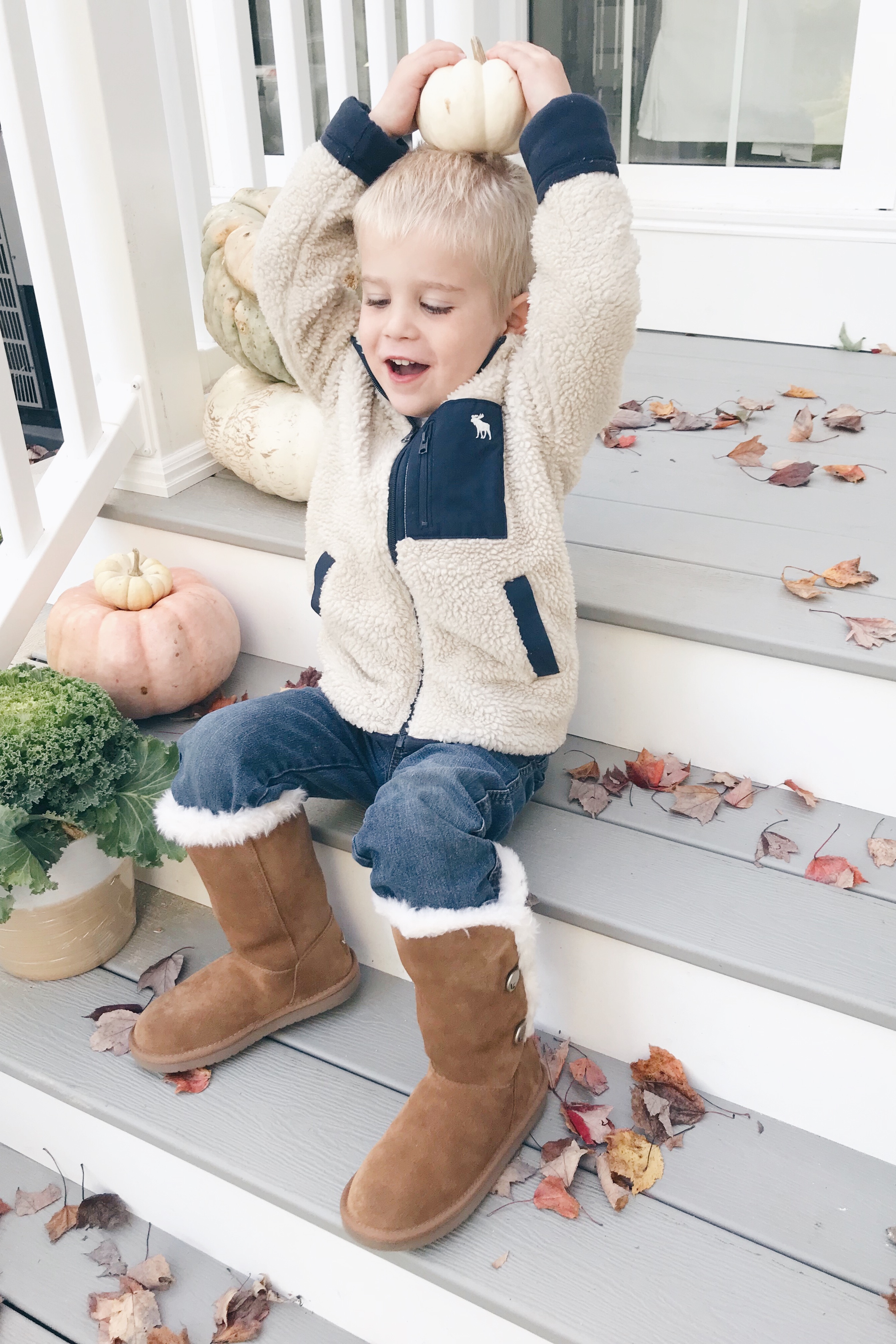 toddler boy on fall porch wearing koolaburra boots
