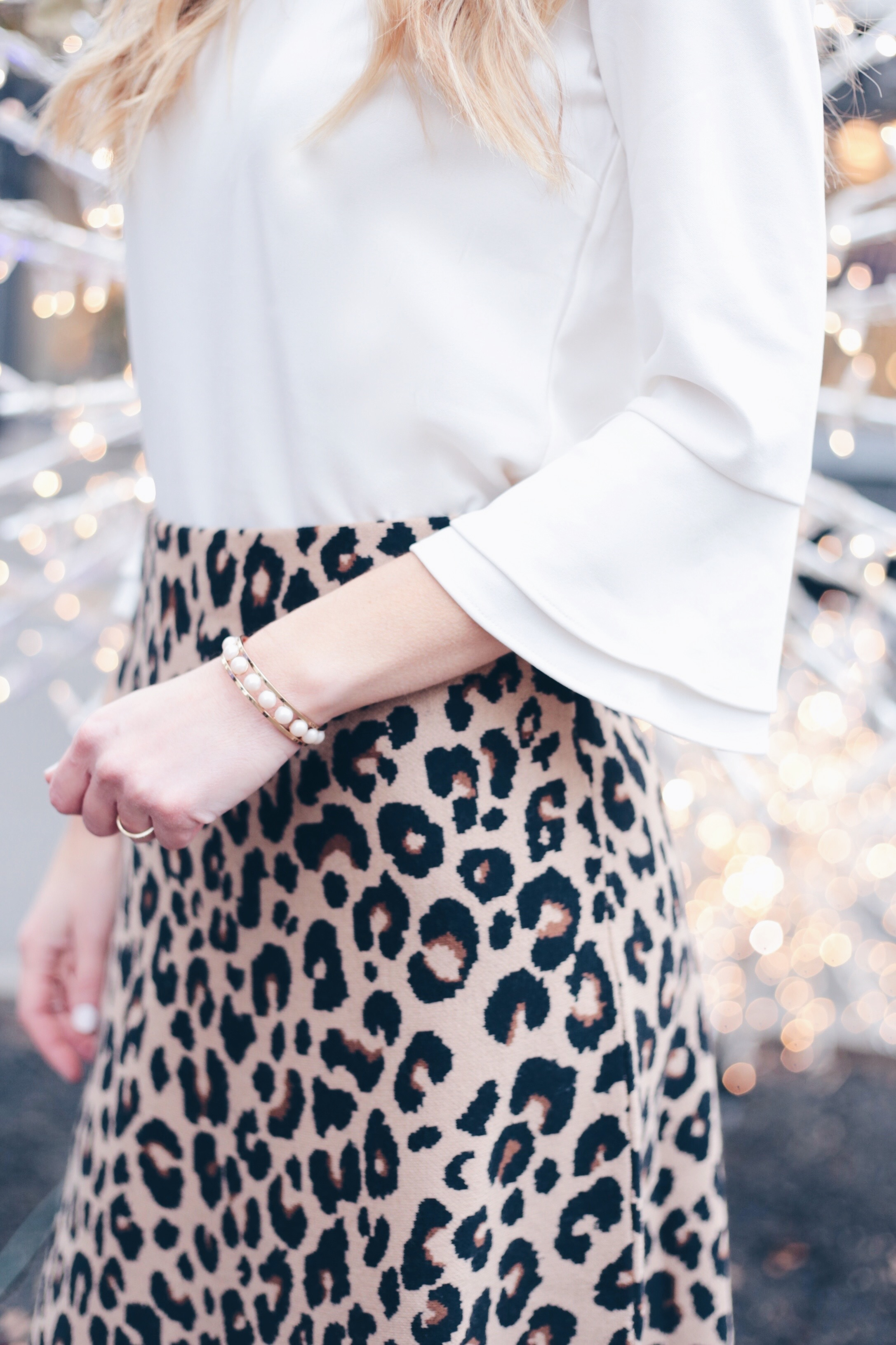  leopard holiday party outfits - white bell sleeve top and leoaprd skirt for the office party
