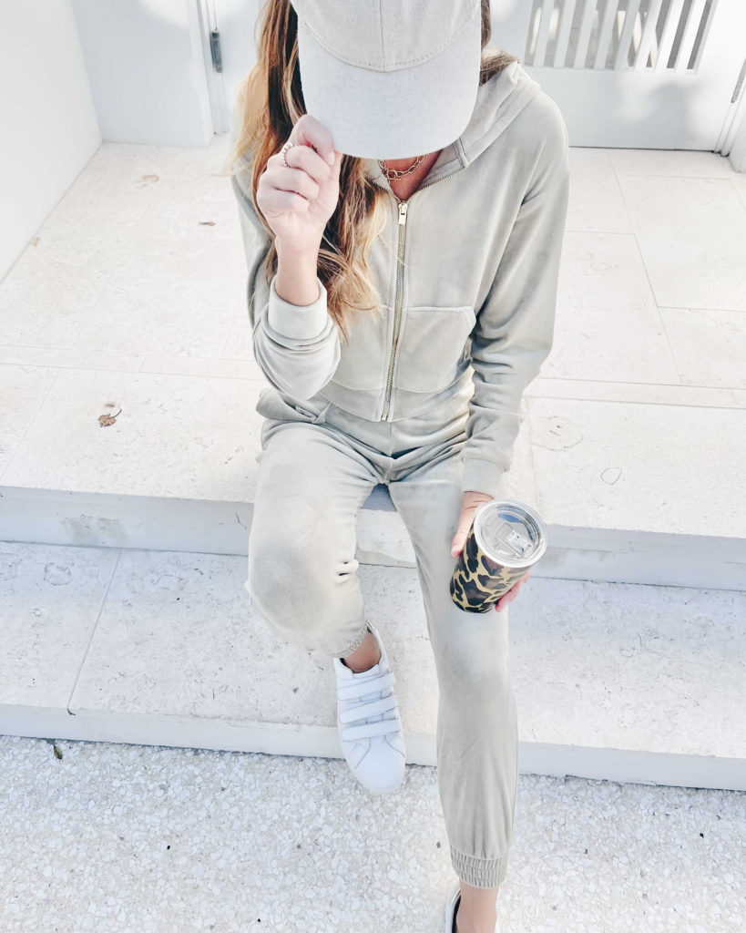 fashion blogger wearing matching velour jogger set with white sneakers