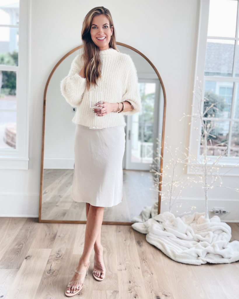winter white holiday party outfit with white sweater over slip dress