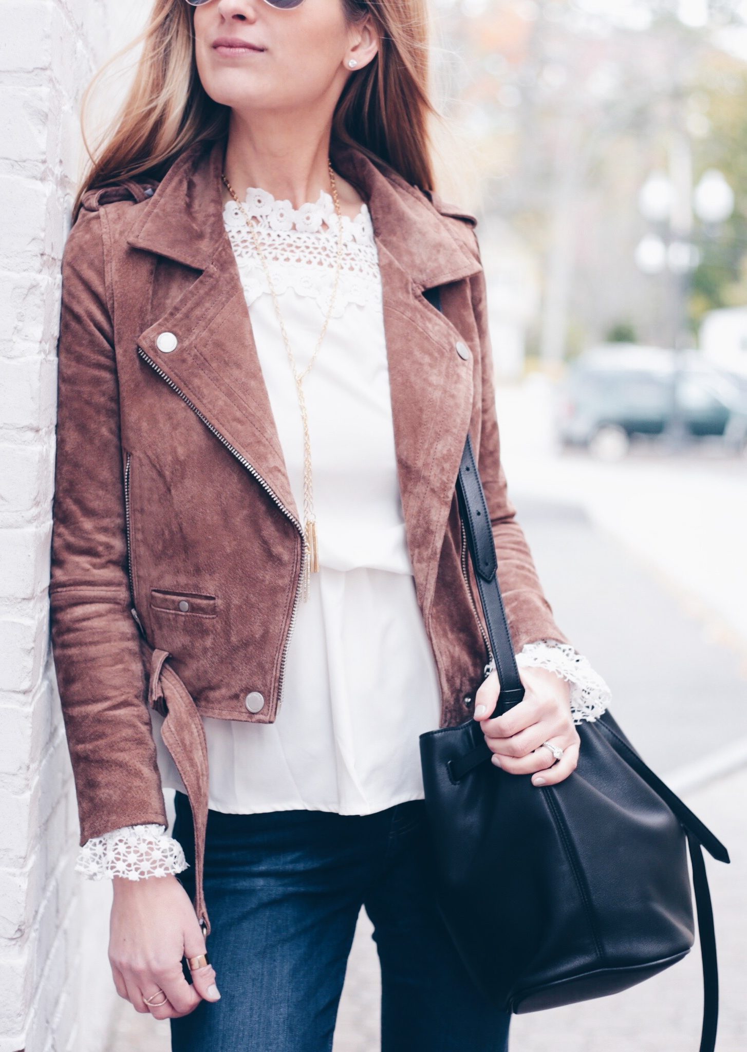blank nyc brown moto jacket with white crochet top and flare denim