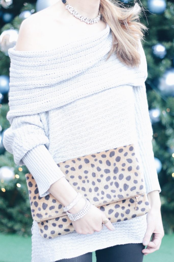 christmas party outfit: off the shoulder sweater with leopard clutch and leather leggings