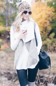 fall outfit: shearling vest over turtleneck sweater and leather leggings with leopard beanie