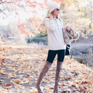 winter outfit: lace up sweater and pom pom knit hat with leather leggings and suede over the knee boots
