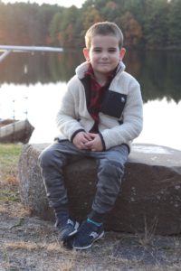 casual holiday outfits for the family - young boy in camo joggers, buffalo plaid shirt and sherpa jacket