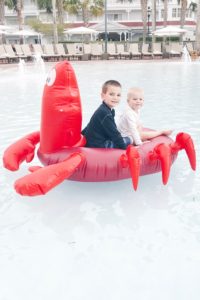 little mermaid pool party - two young boys on sebastian pool float