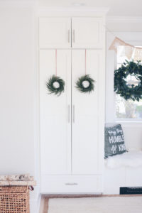 simple holiday mudroom decor - wreaths on white shaker doors on pinteresting plans blog