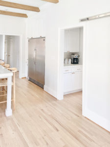 modern white kitchen with faux wood ceiling beams and side by side full fridge and freezer - pinteresting plans blog