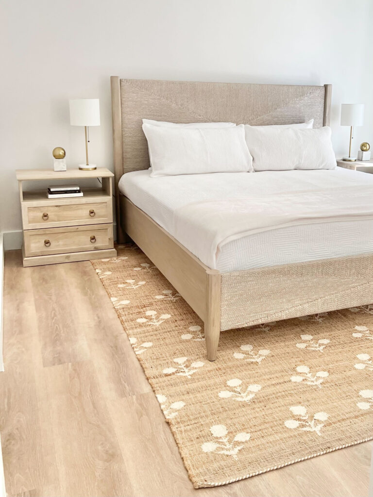 natural woven jute rug under woven bed in primary bedroom