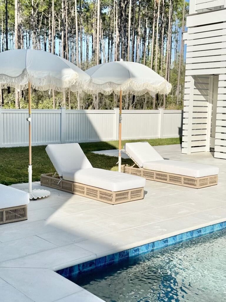 white outdoor chaise lounge pool chair with fringe patio umbrellas