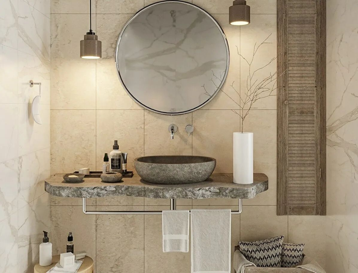 Biophilic Bathroom Design for 2025: A modern bathroom showcasing 2025’s biophilic design trend with a floating stone sink, natural wood finishes, and a large round mirror. Earthy tones, warm ambient lighting, and organic materials create a serene and nature-inspired retreat.