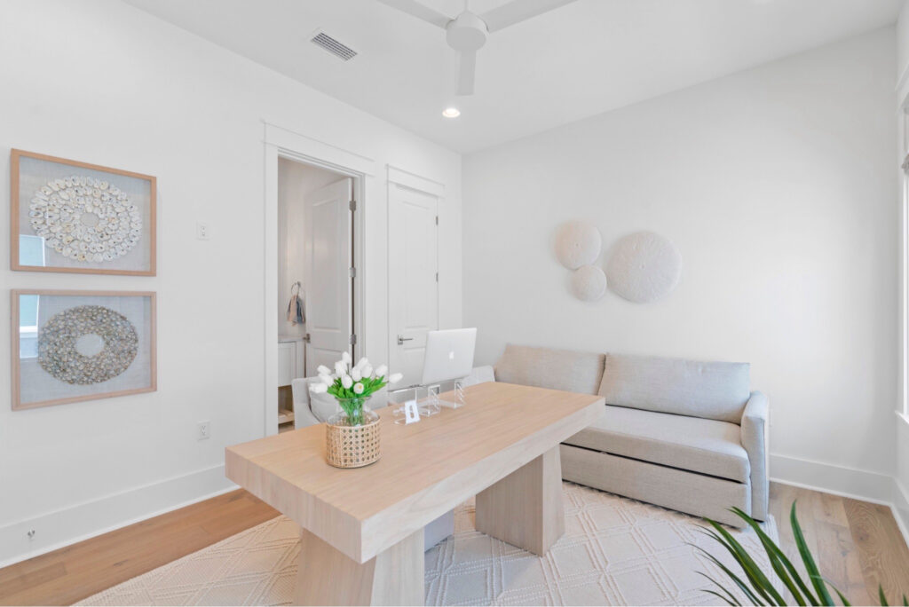 Minimalist home office with a light wood desk and a trundle bed sofa, showcasing a stylish and functional flex space design for 2025.