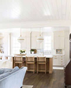 Bright kitchen interior featuring Benjamin Moore Edgecomb Gray cabinets paired with warm wood accents and woven barstools.