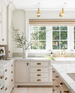Chic kitchen design with Benjamin Moore Edgecomb Gray cabinets, brass hardware, and marble countertops.