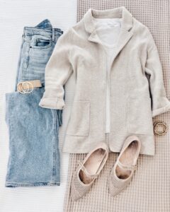 Effortlessly chic business casual outfit for women over 40 with light-wash denim, an oatmeal wool coat, white tee, nude Mary Jane flats, and a neutral belt.
